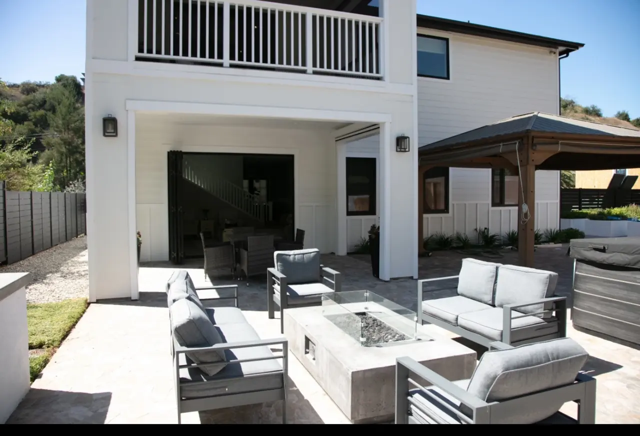 A patio with couches and fire pit in the middle of it.