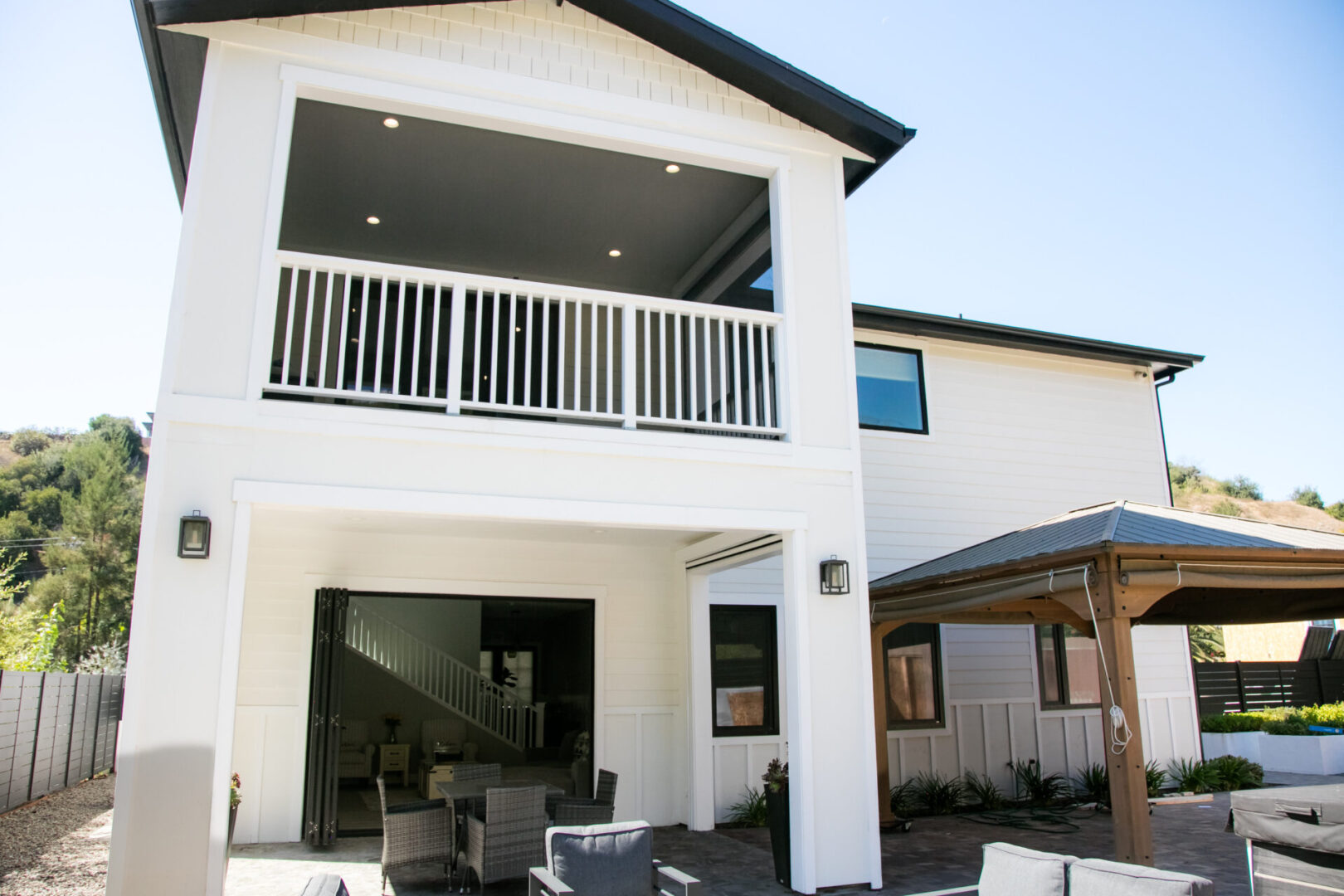 A large white house with a balcony and patio.