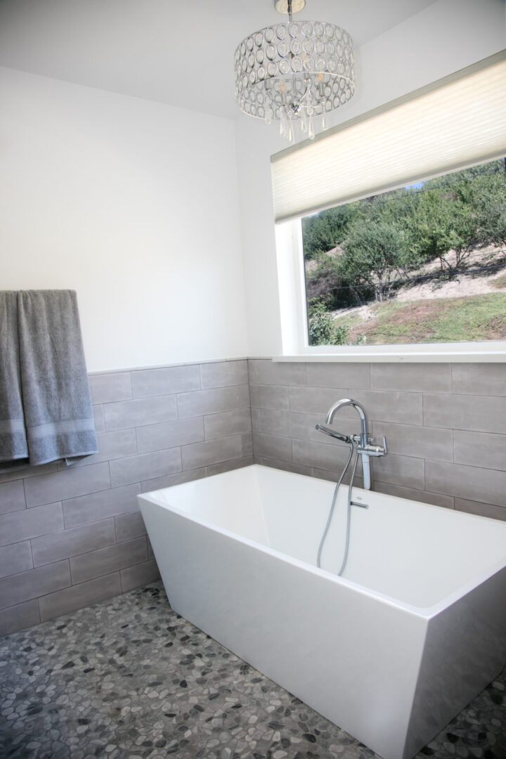 A bathroom with a tub and window in it